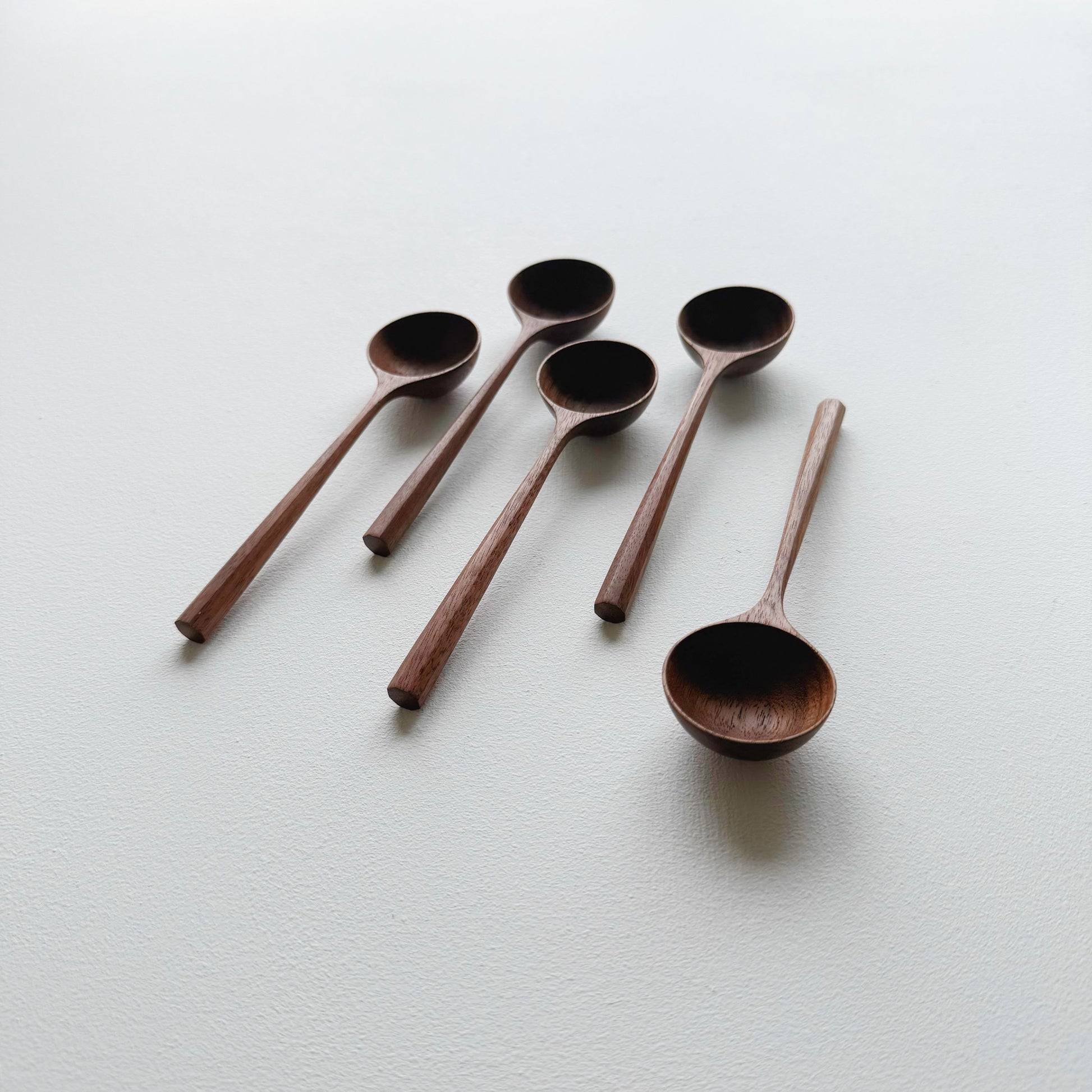 Set of five walnut wood scoop on a white background
