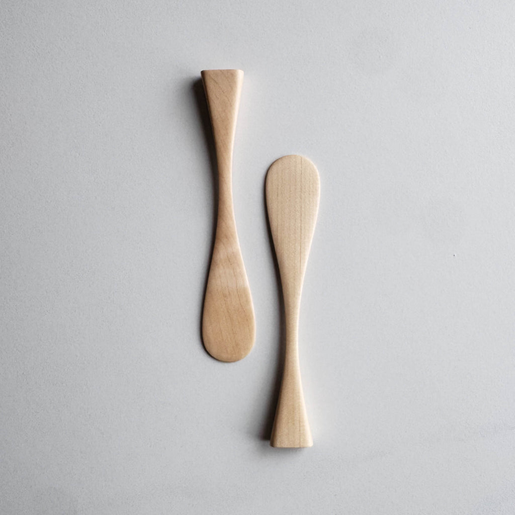 Two sycamore wood butter knives on a white background