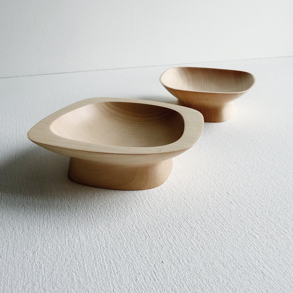 Two curved sycamore plinth bowls on a white background