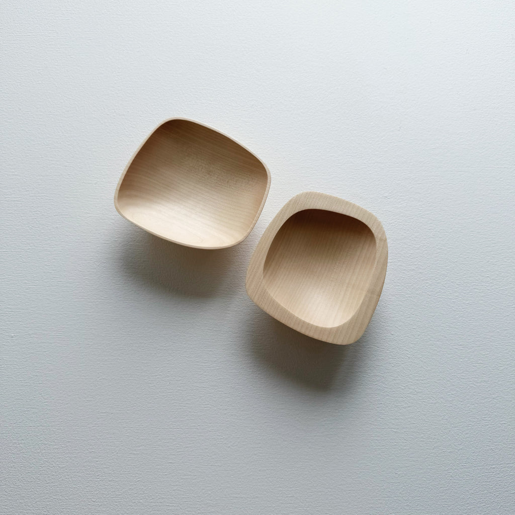 Two curved sycamore plinth bowls on a white background