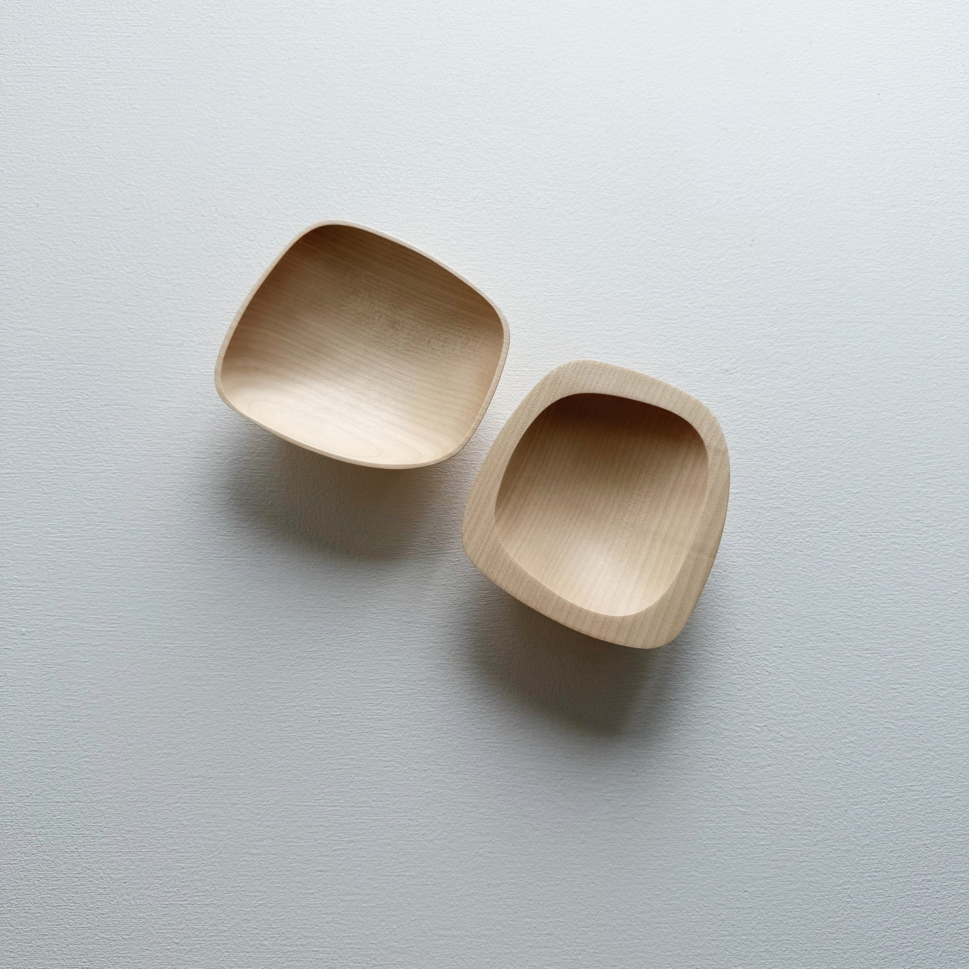 Two curved sycamore plinth bowls on a white background