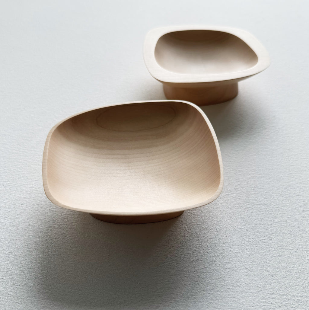 Two curved sycamore plinth bowls on a white background