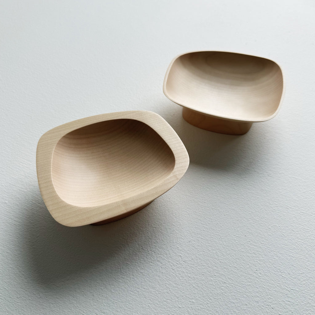 Two curved sycamore plinth bowls on a white background