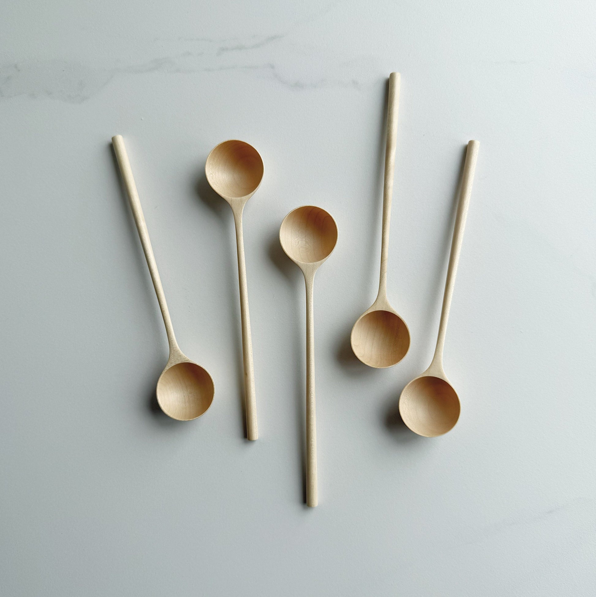 Set of five sycamore long stem spoons on a light background