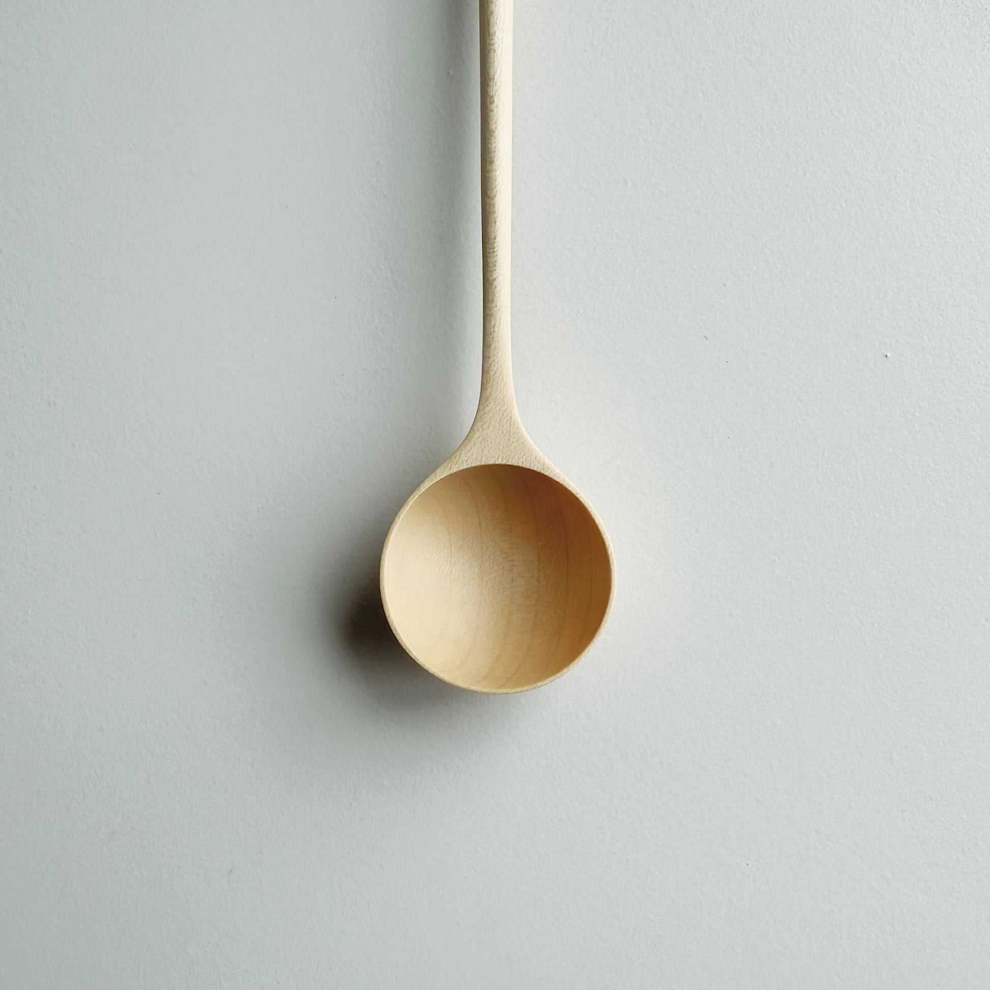 Close up of sycamore long stem spoon on a light background
