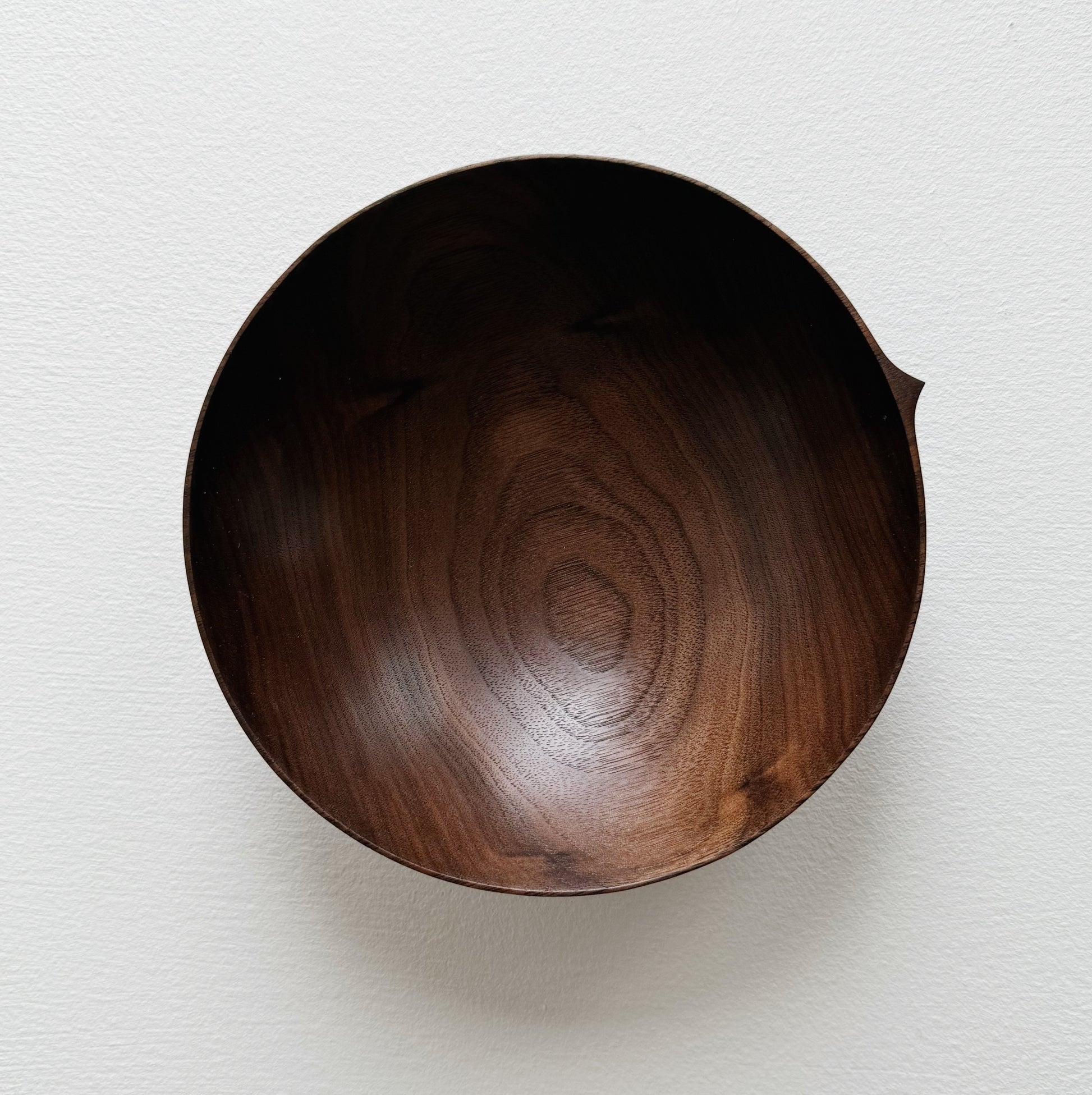 Walnut wood bowl on a light gray background