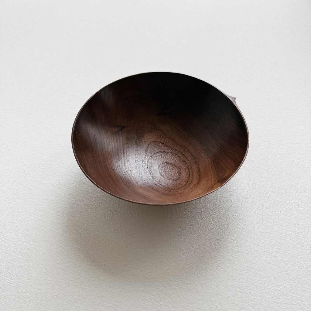 Walnut wood bowl on a light gray background
