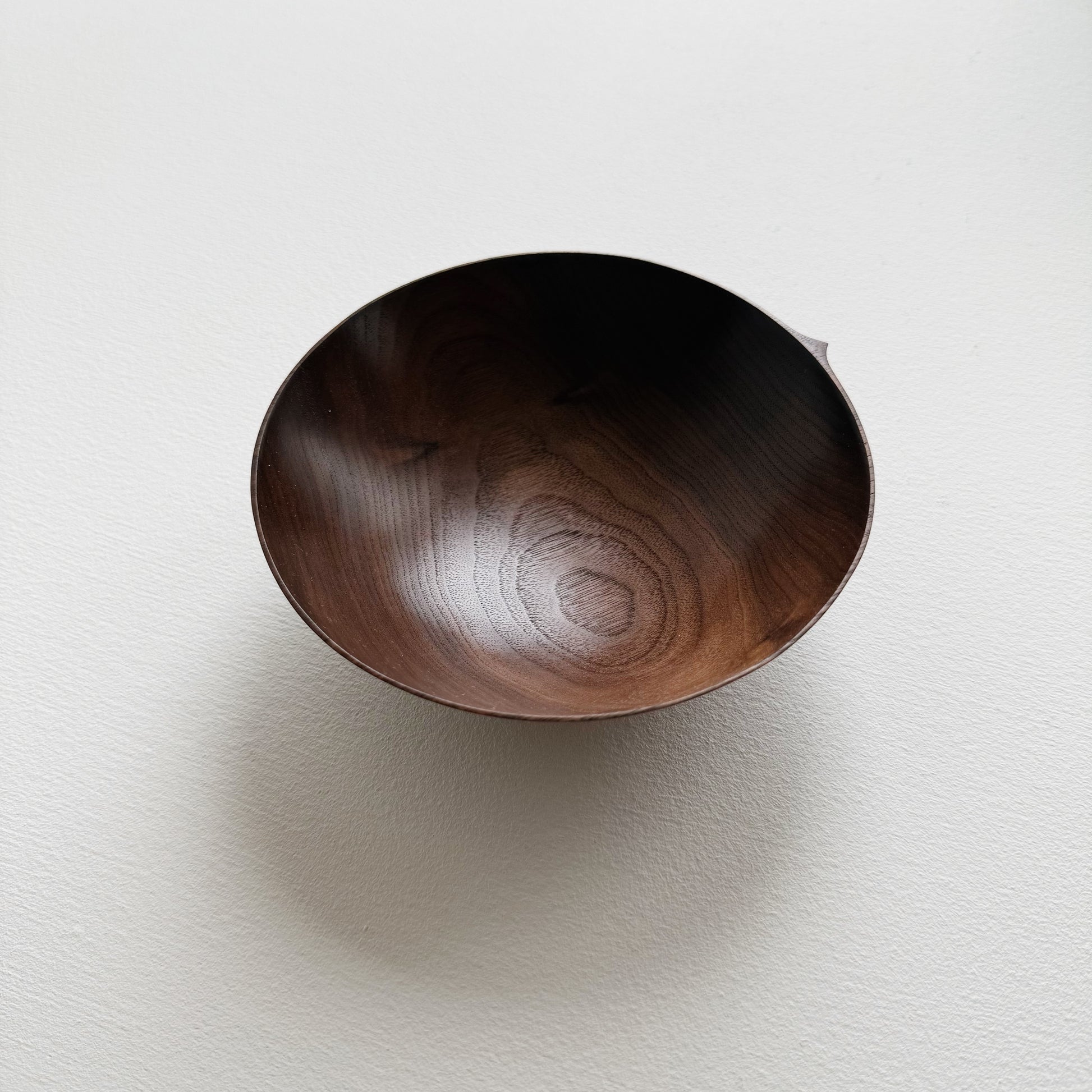 Walnut wood bowl on a light gray background