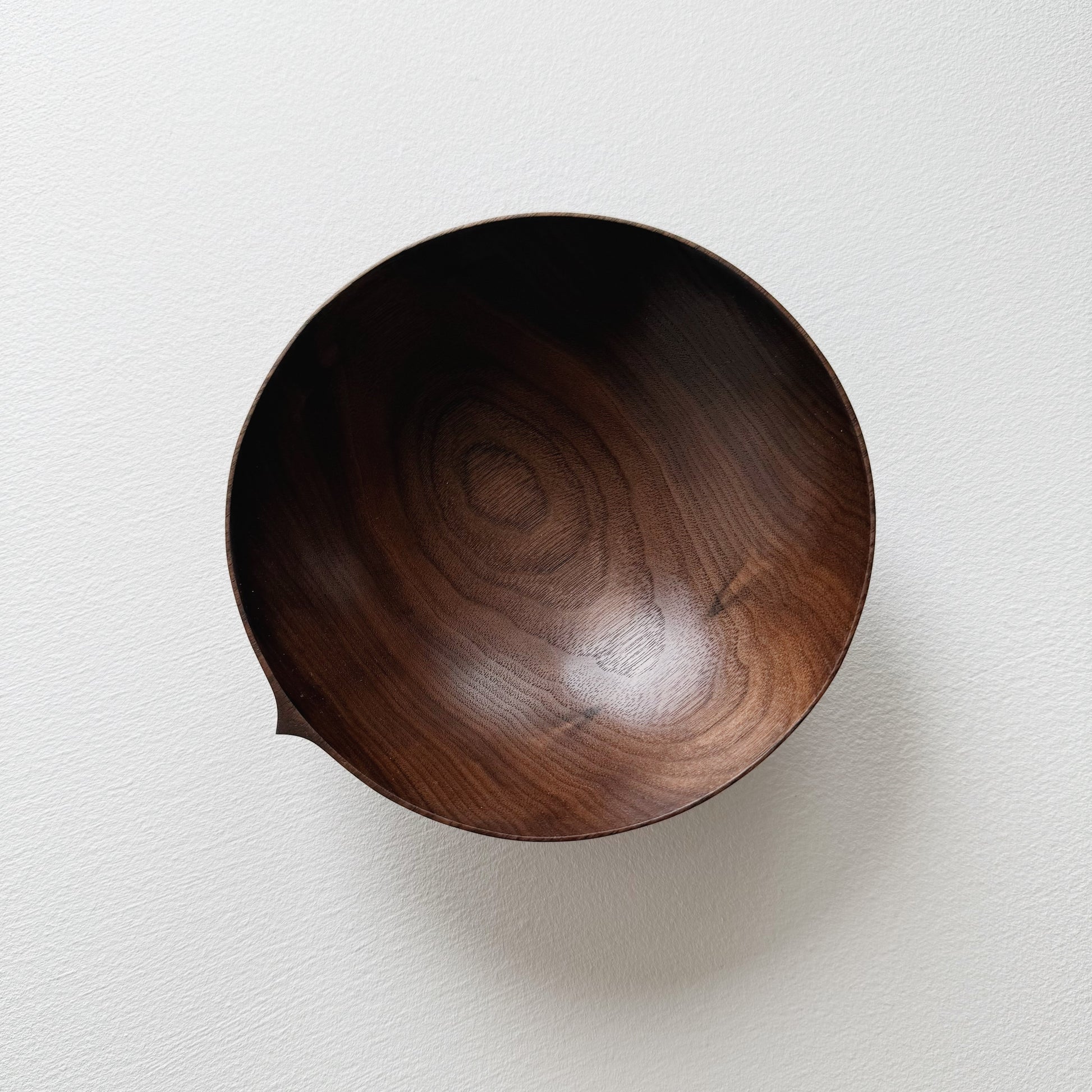 Walnut wood bowl on a light gray background