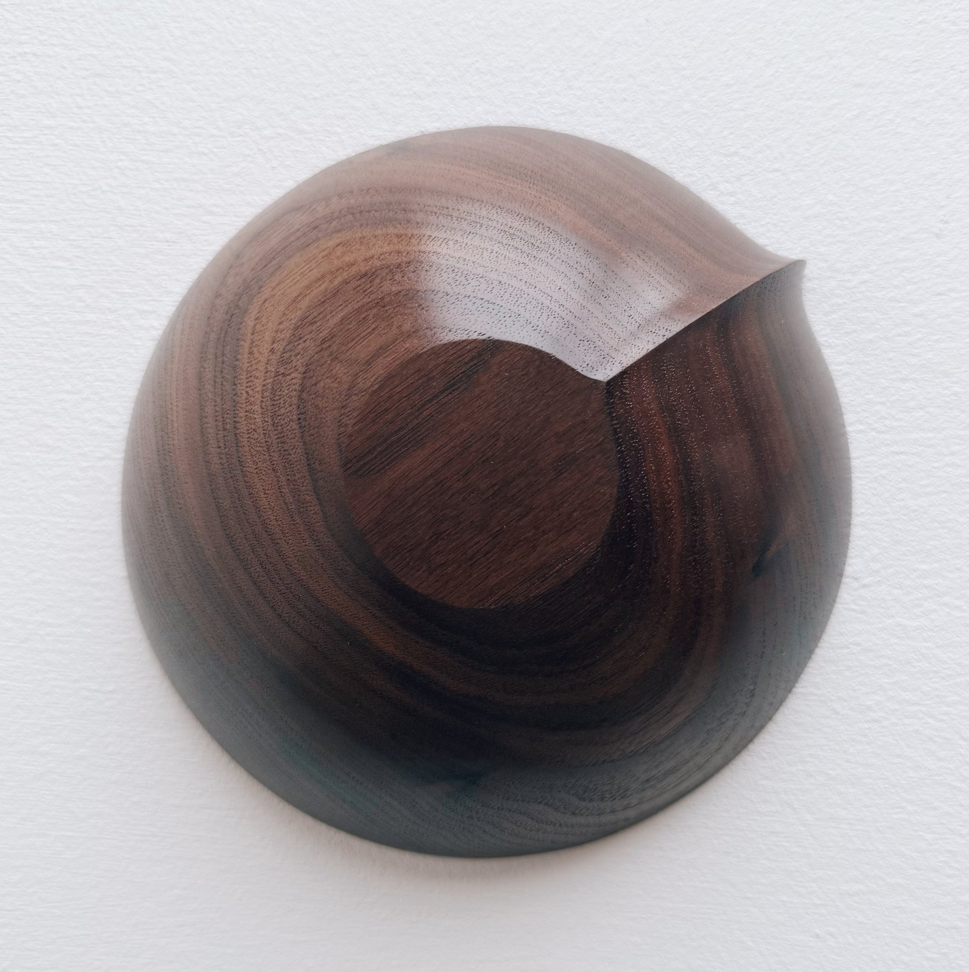 Walnut wooden bowl upside down on a light gray background