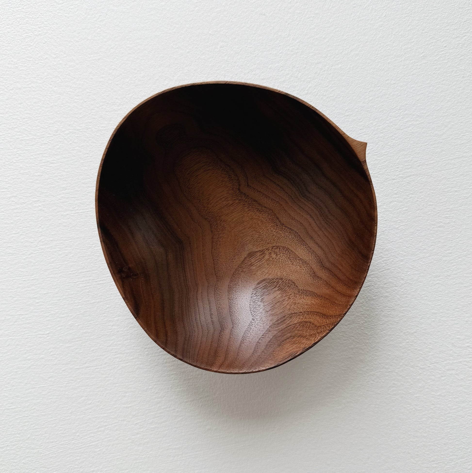 Walnut wood bowl on a light gray background