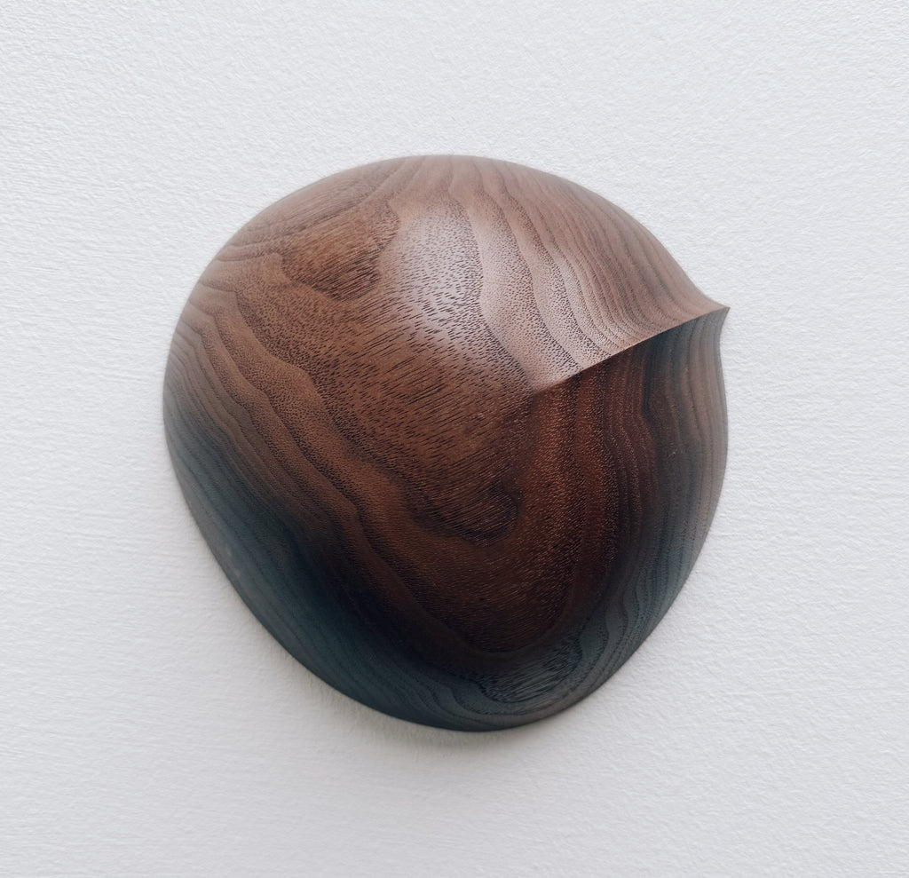 Walnut wood bowl on a light gray background
