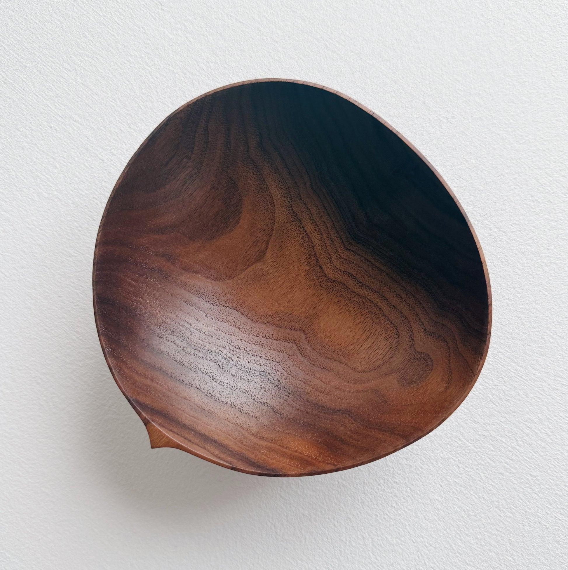 Walnut wood bowl with a dark brown finish on a white background
