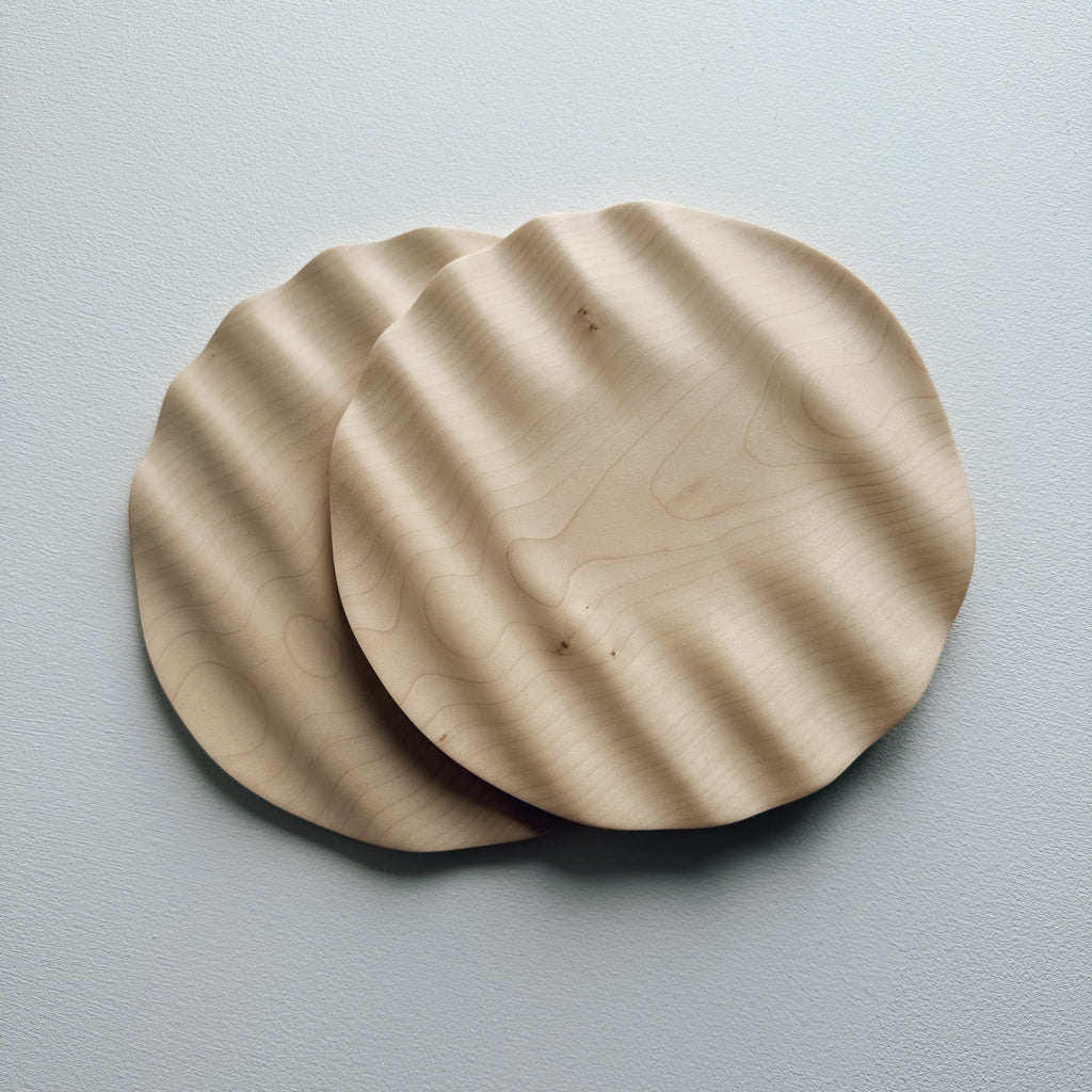 Two sycamore wavy plates on a white background