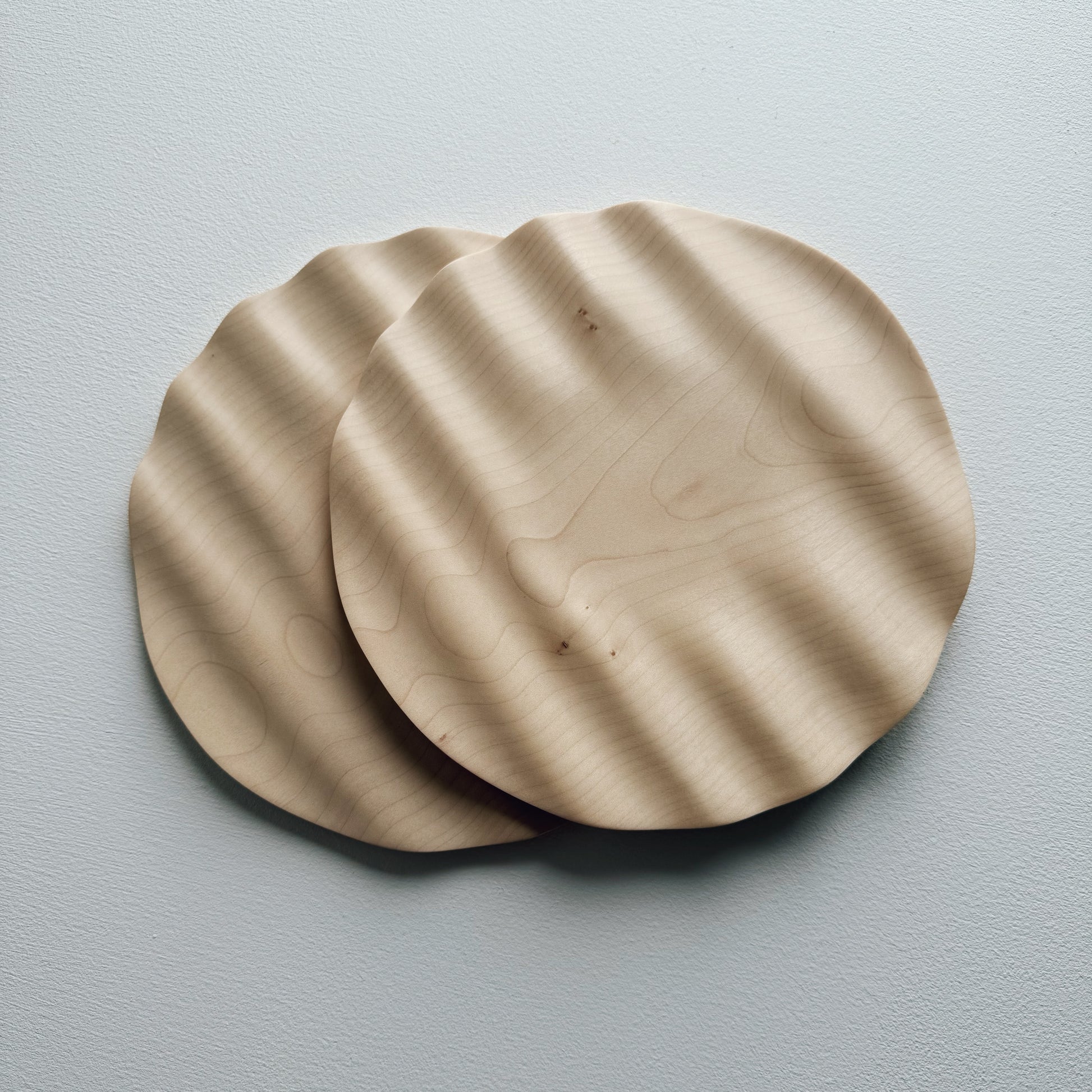 Two sycamore wavy plates on a white background