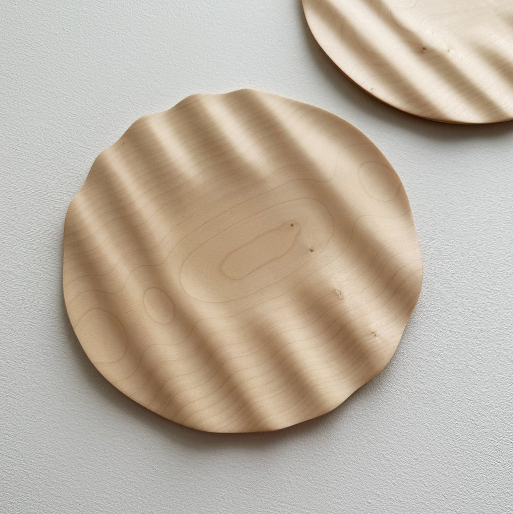 Two sycamore wavy plates on a white background