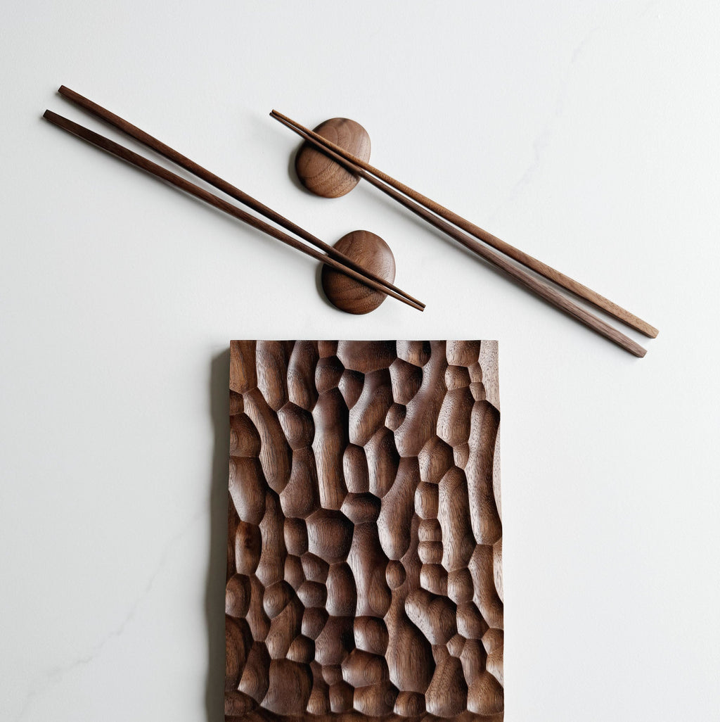 Wide presentation board with crater design in walnut, with wooden chopsticks & pebble rests.
