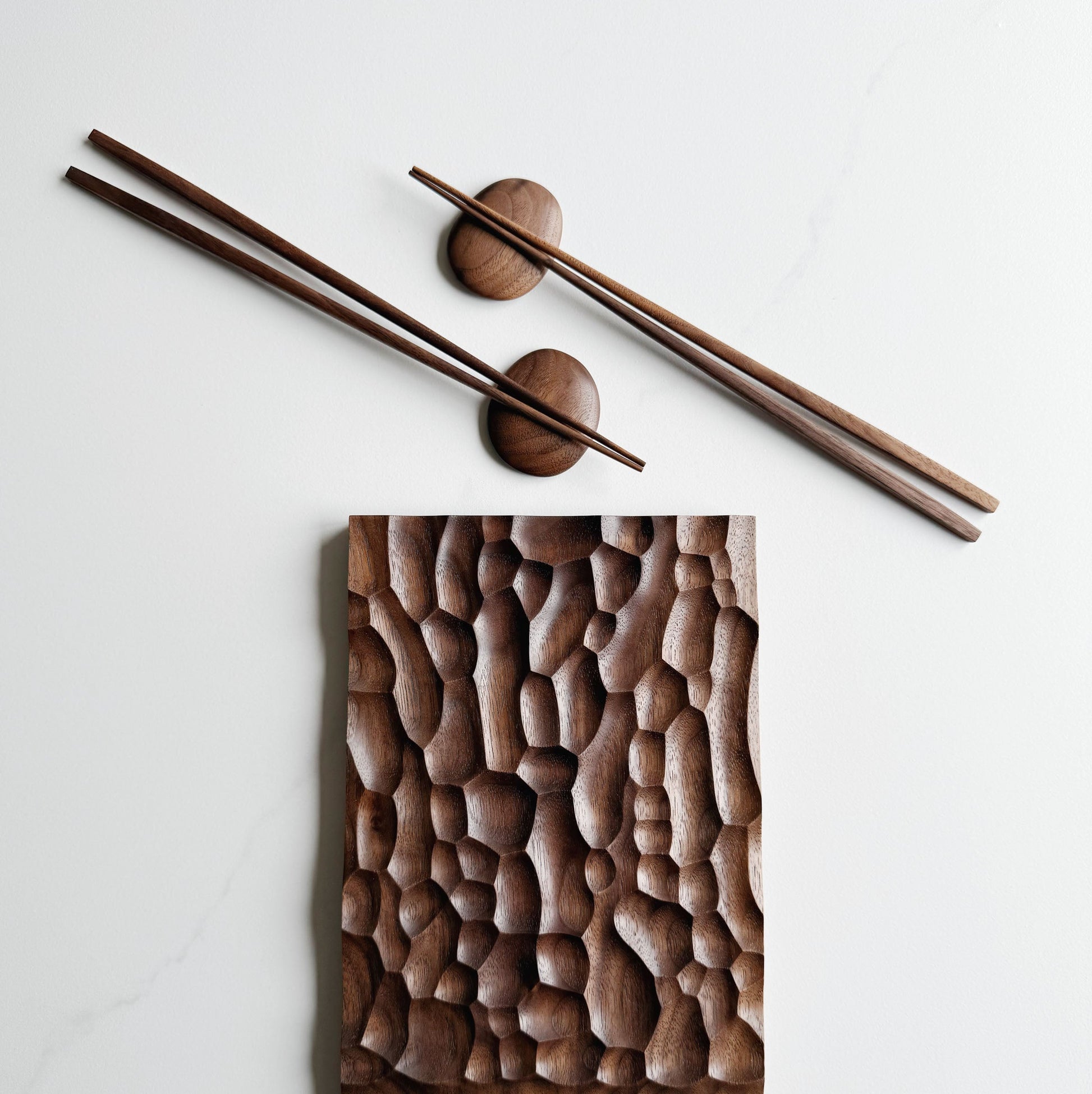 Wide presentation board with crater design in walnut, with wooden chopsticks & pebble rests.
