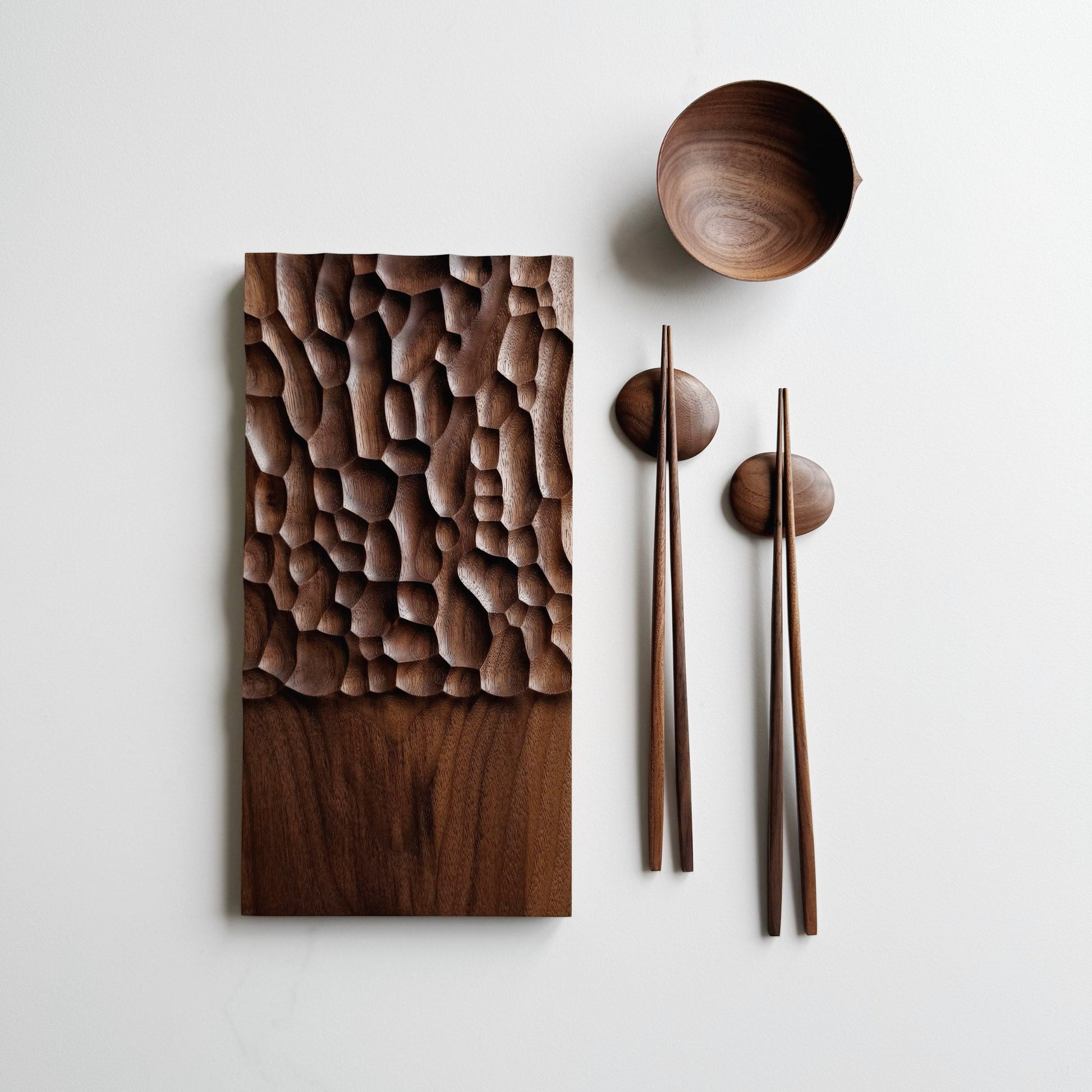 Wide presentation board with crater design in walnut, with a bowl, wooden chopsticks & pebble rests.