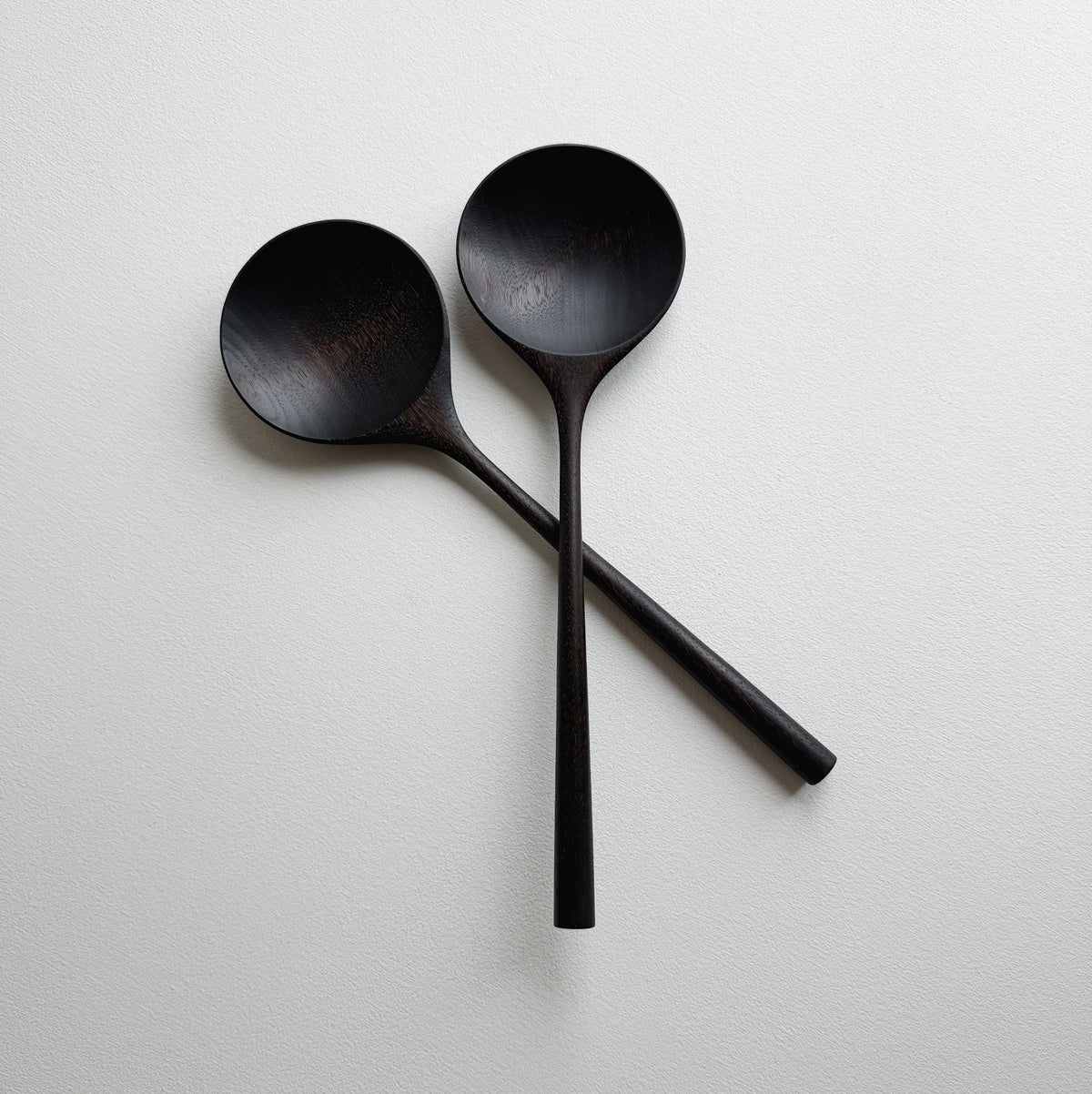 Pair of large serving spoons in ebonised walnut