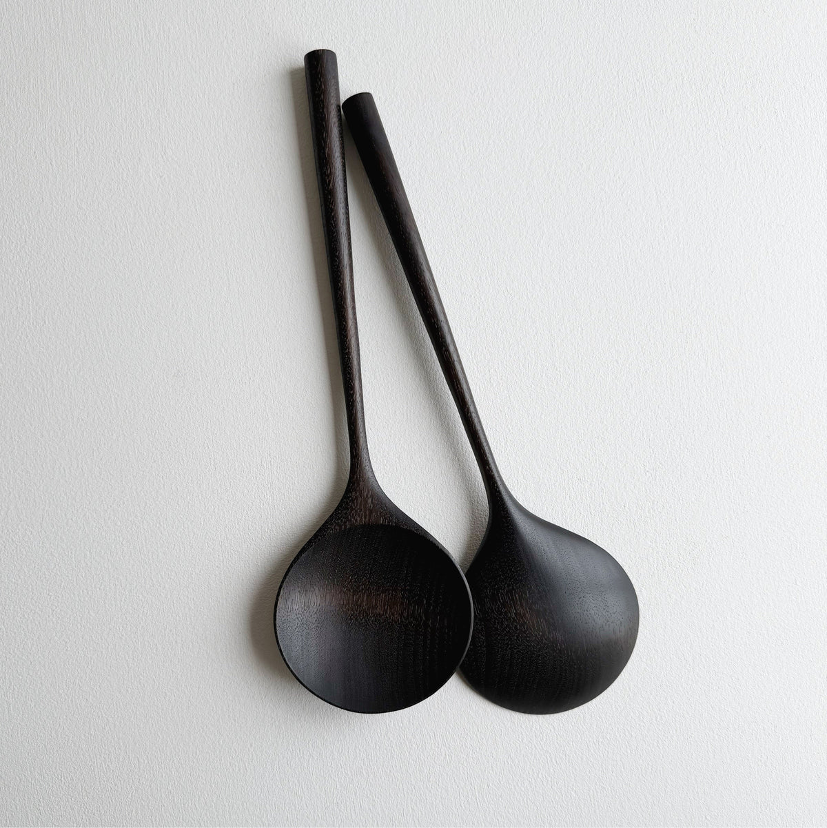 Pair of large serving spoons in ebonised walnut