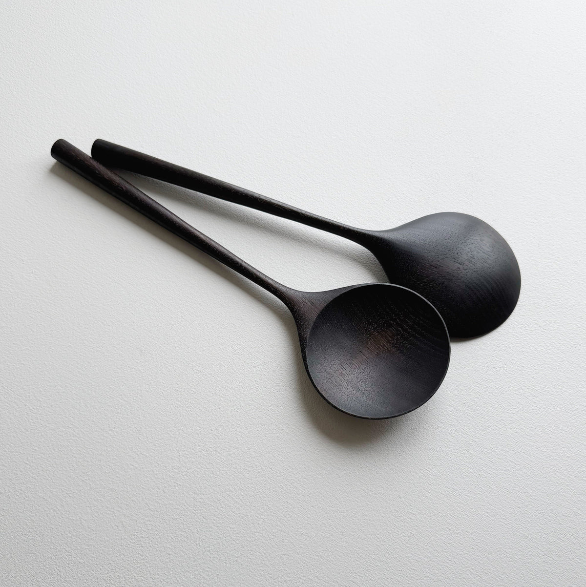 Pair of large serving spoons in ebonised walnut