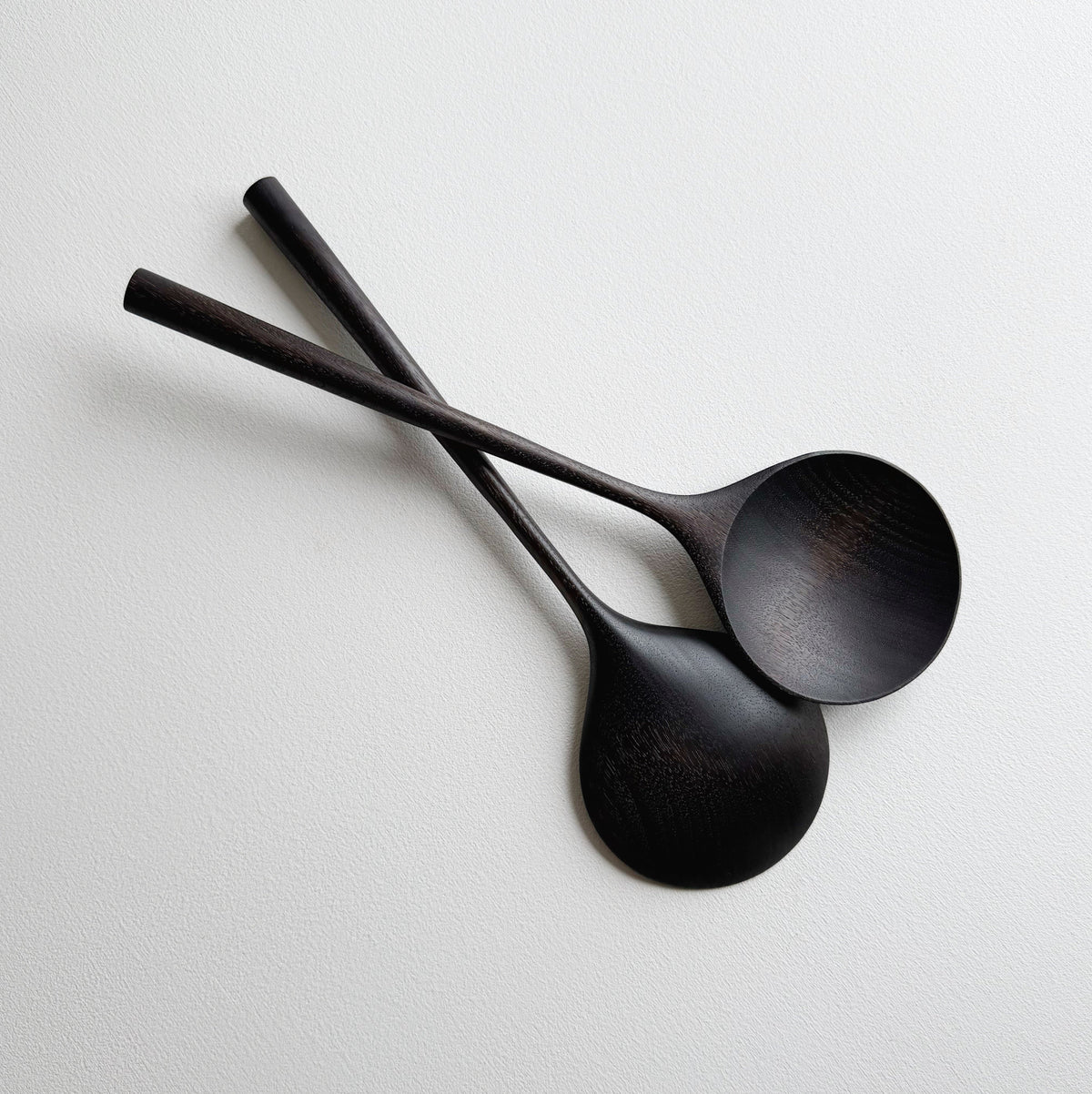 Pair of large serving spoons in ebonised walnut