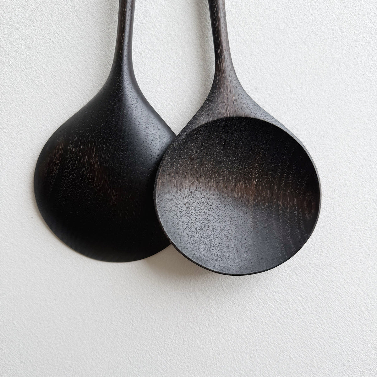 Pair of large serving spoons in ebonised walnut