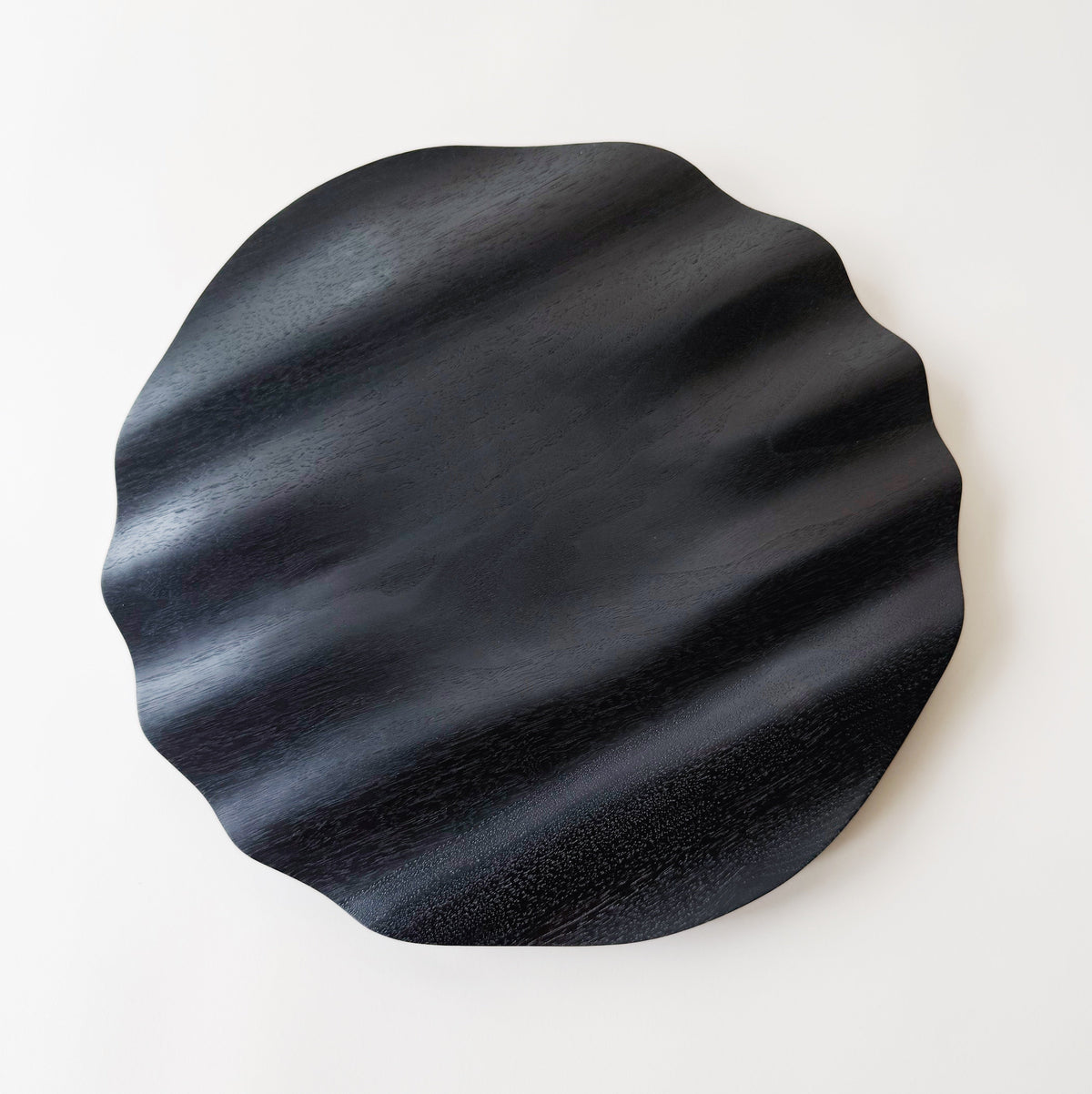Wavy charger plate in ebonised walnut