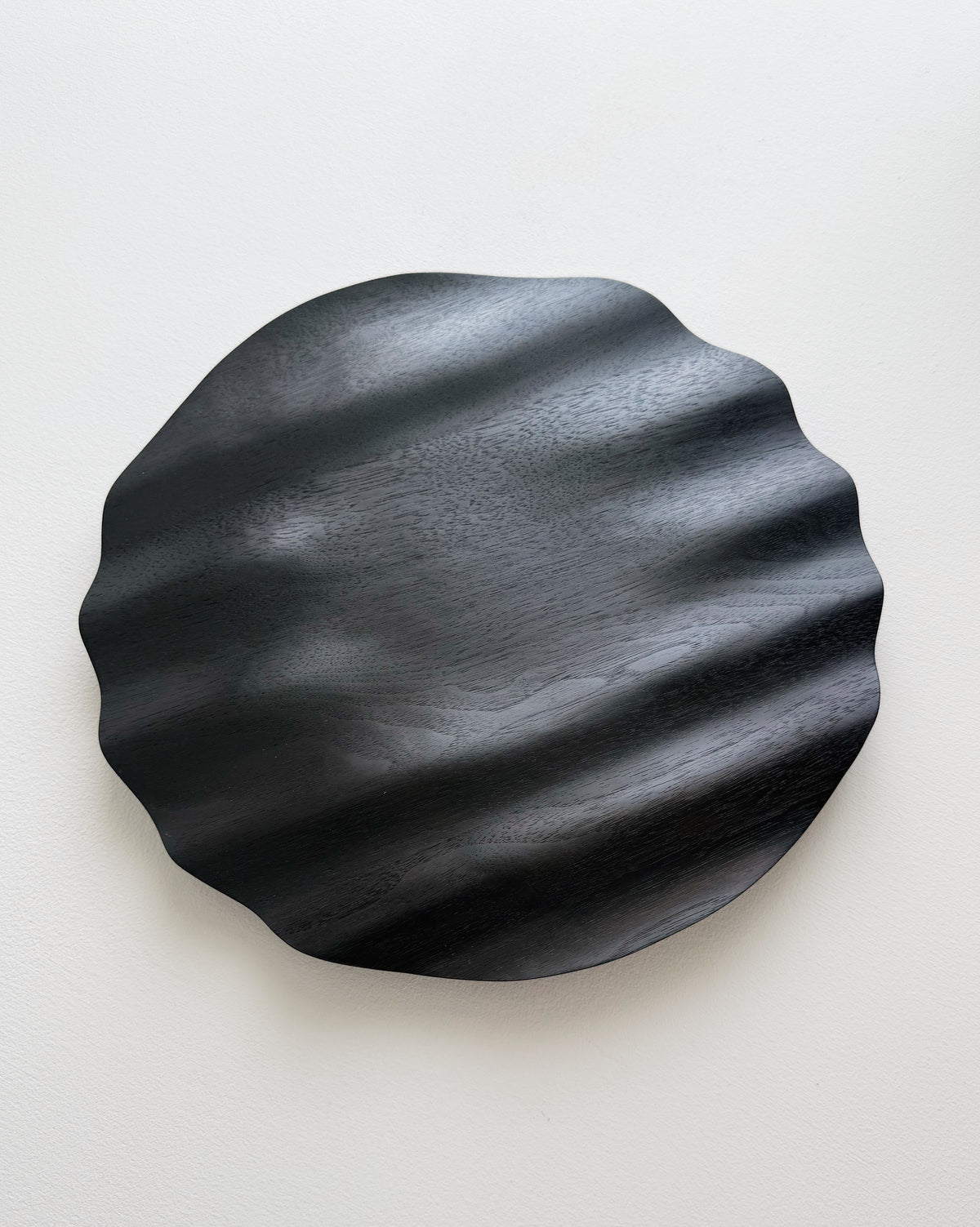 Wavy charger plate in ebonised walnut