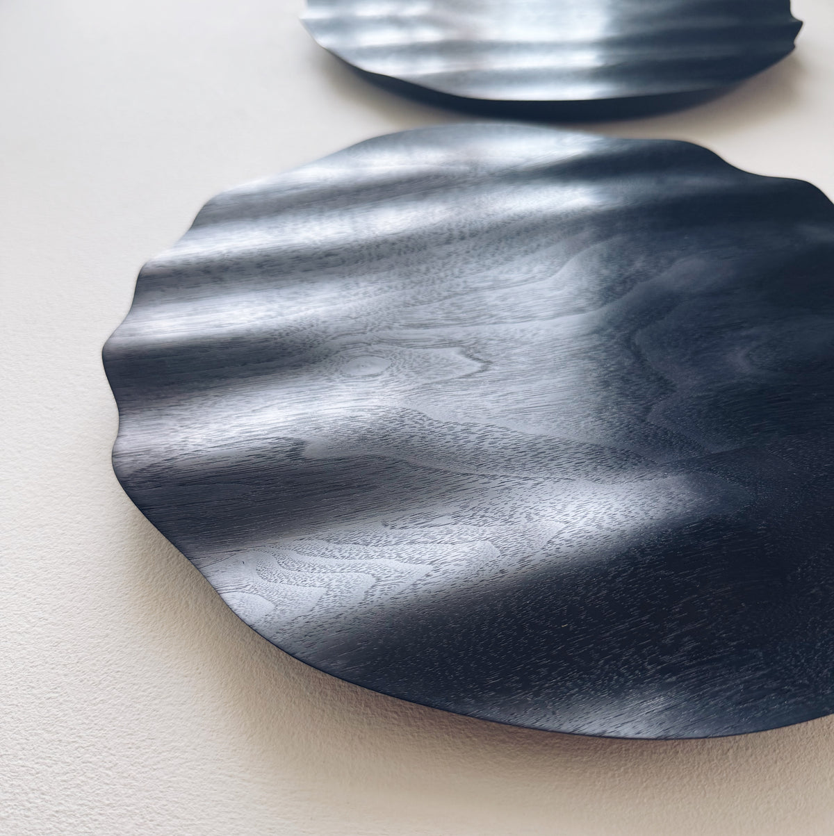 Wavy charger plate in ebonised walnut