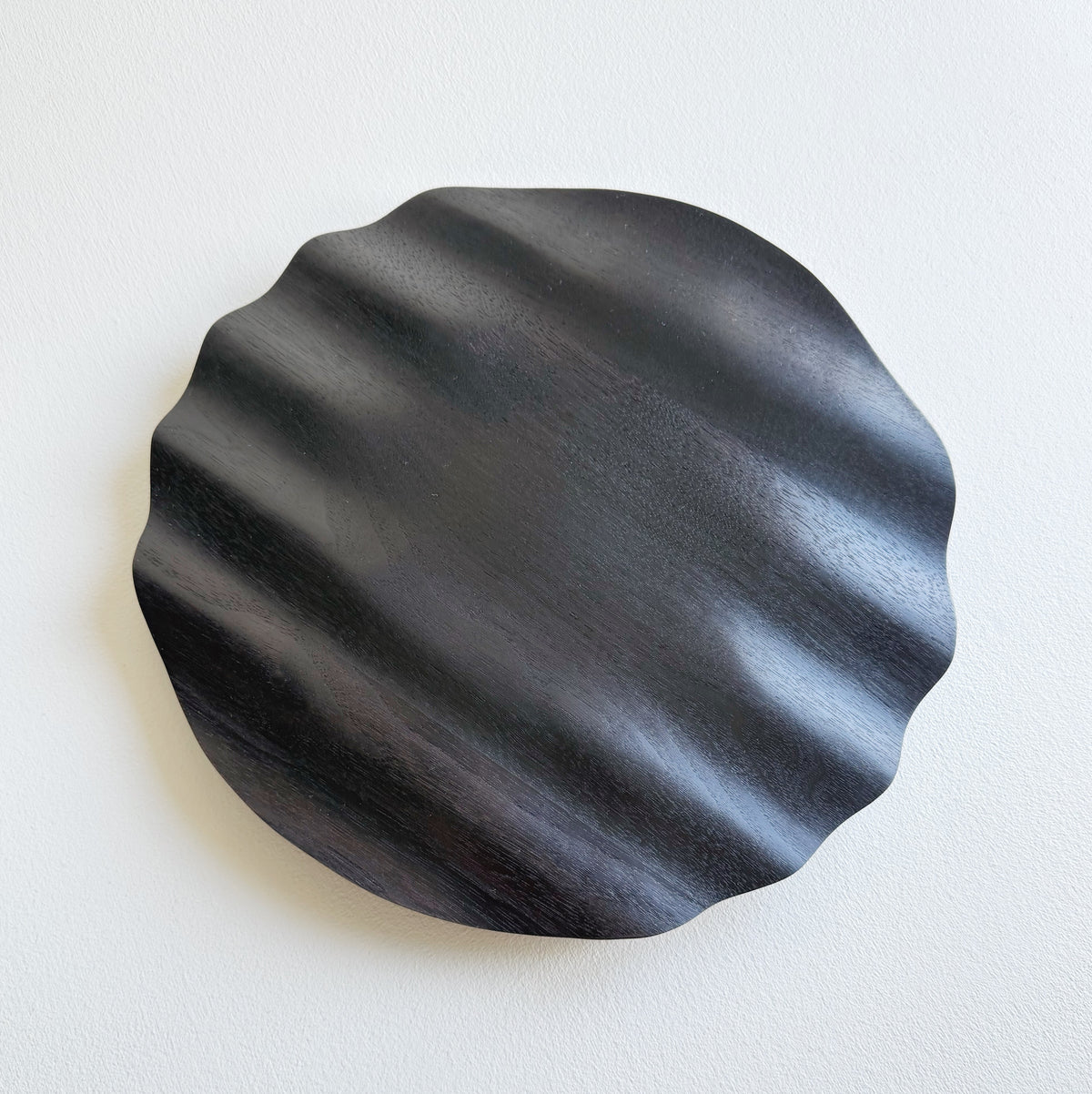 Wavy charger plate in ebonised walnut